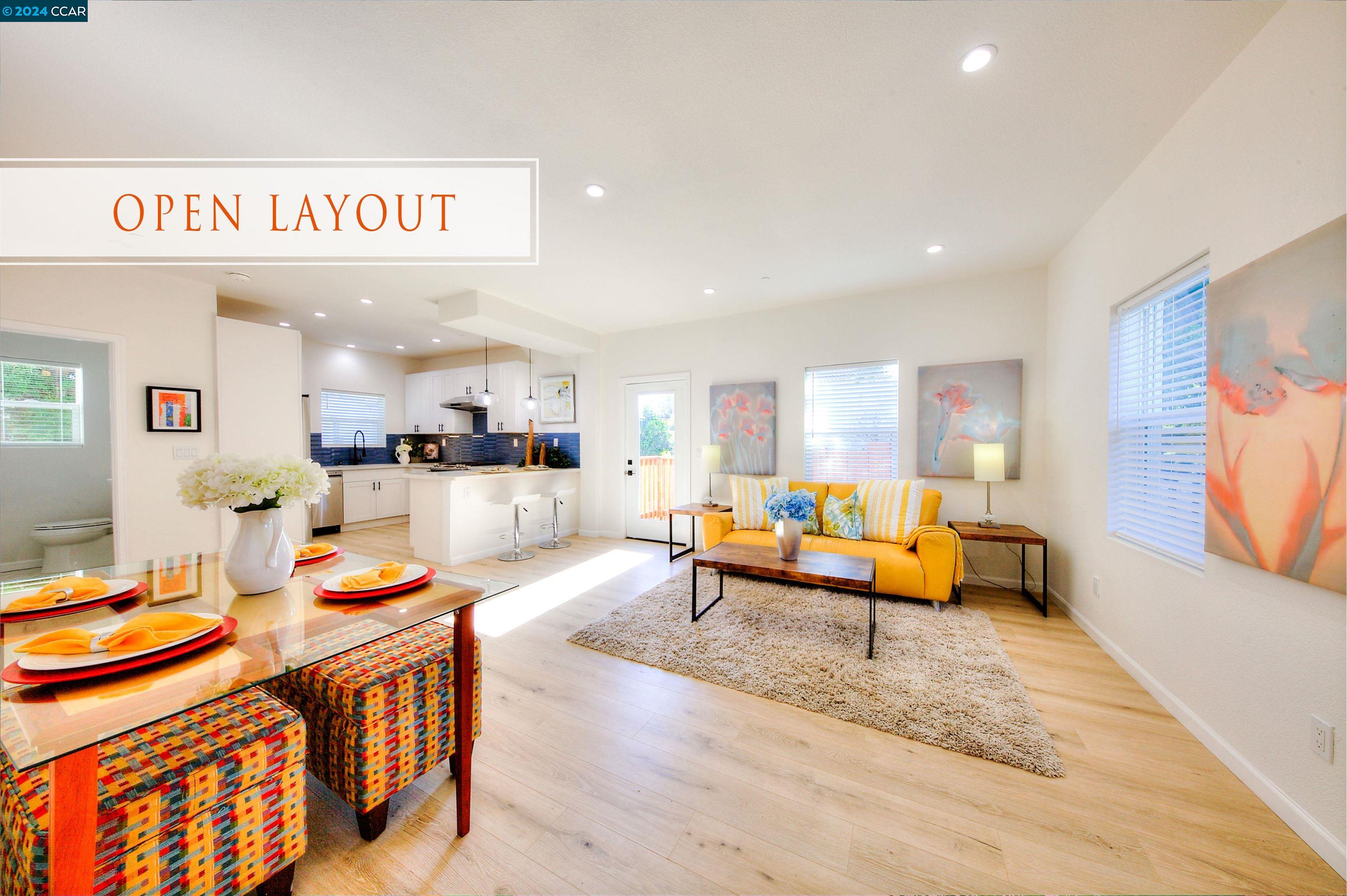 a living room with furniture kitchen view and a large window