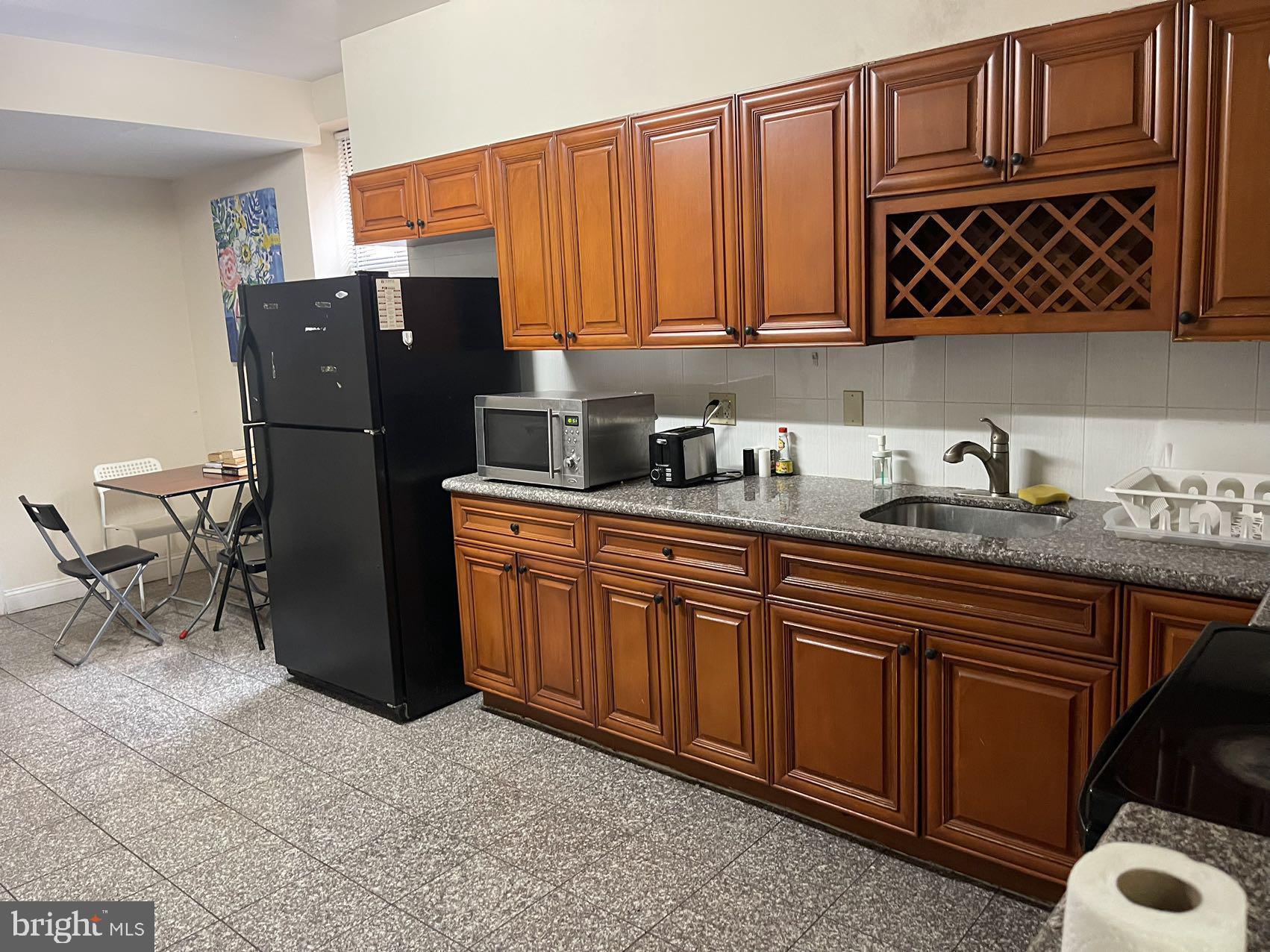 a kitchen with stainless steel appliances granite countertop a refrigerator and wooden cabinets