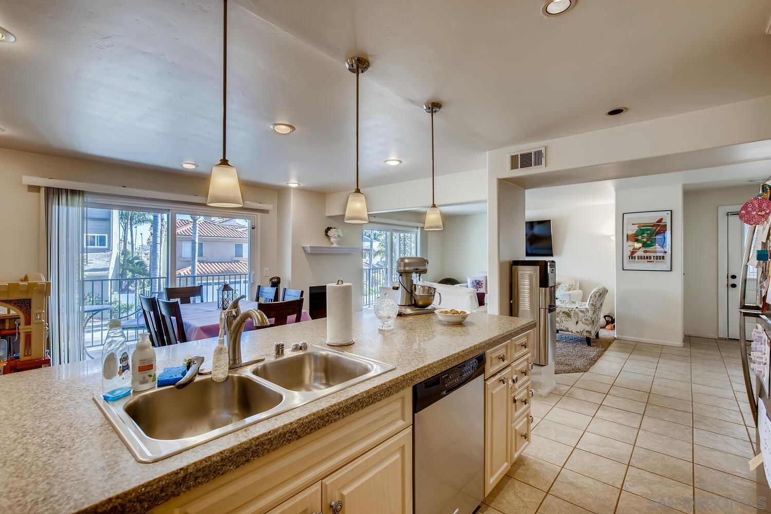 a kitchen with a sink a counter and chairs in it