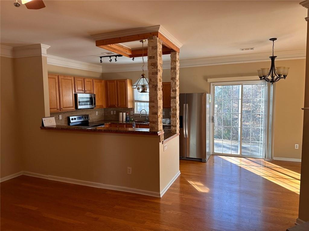 a view of a hallway with wooden floor and windows