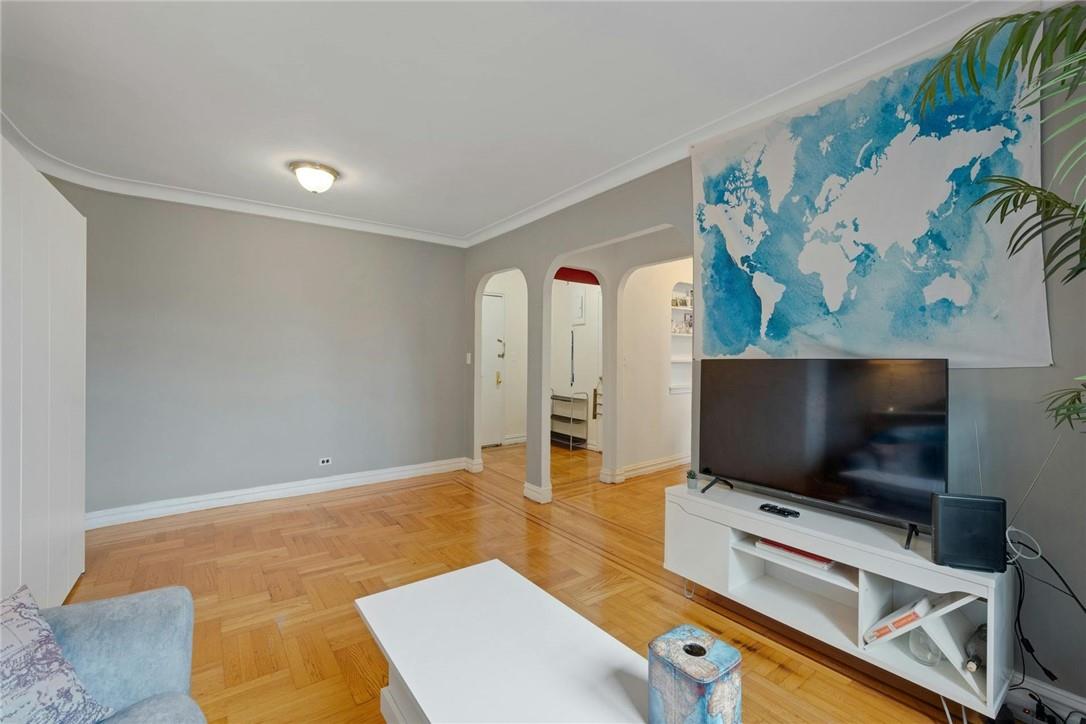 Living room featuring ornamental molding and light parquet flooring