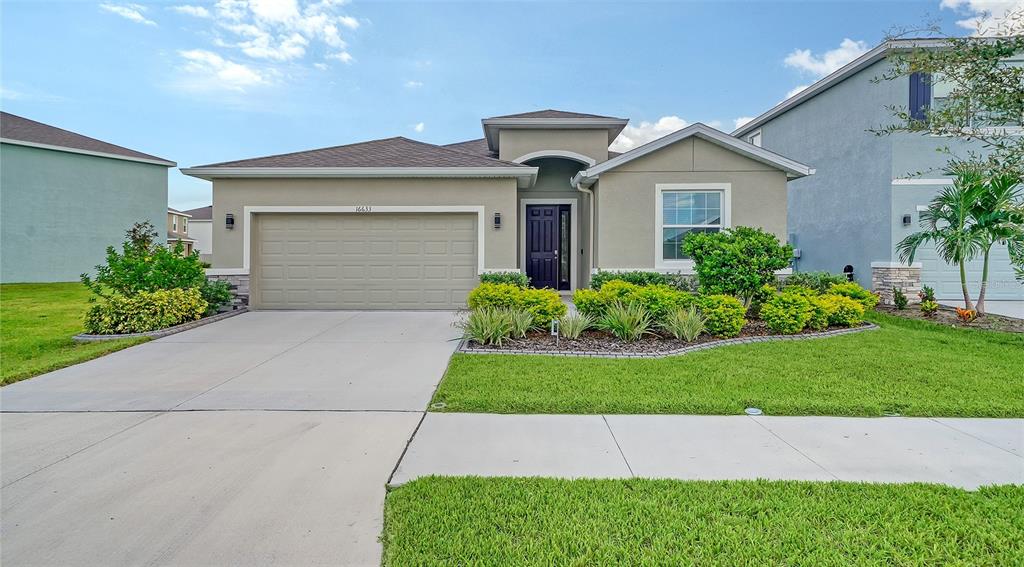 a front view of a house with a yard and garage