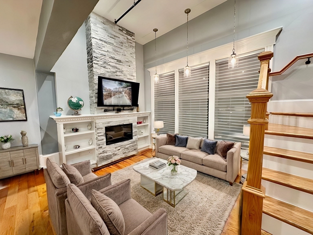 a living room with furniture a flat screen tv and a fireplace