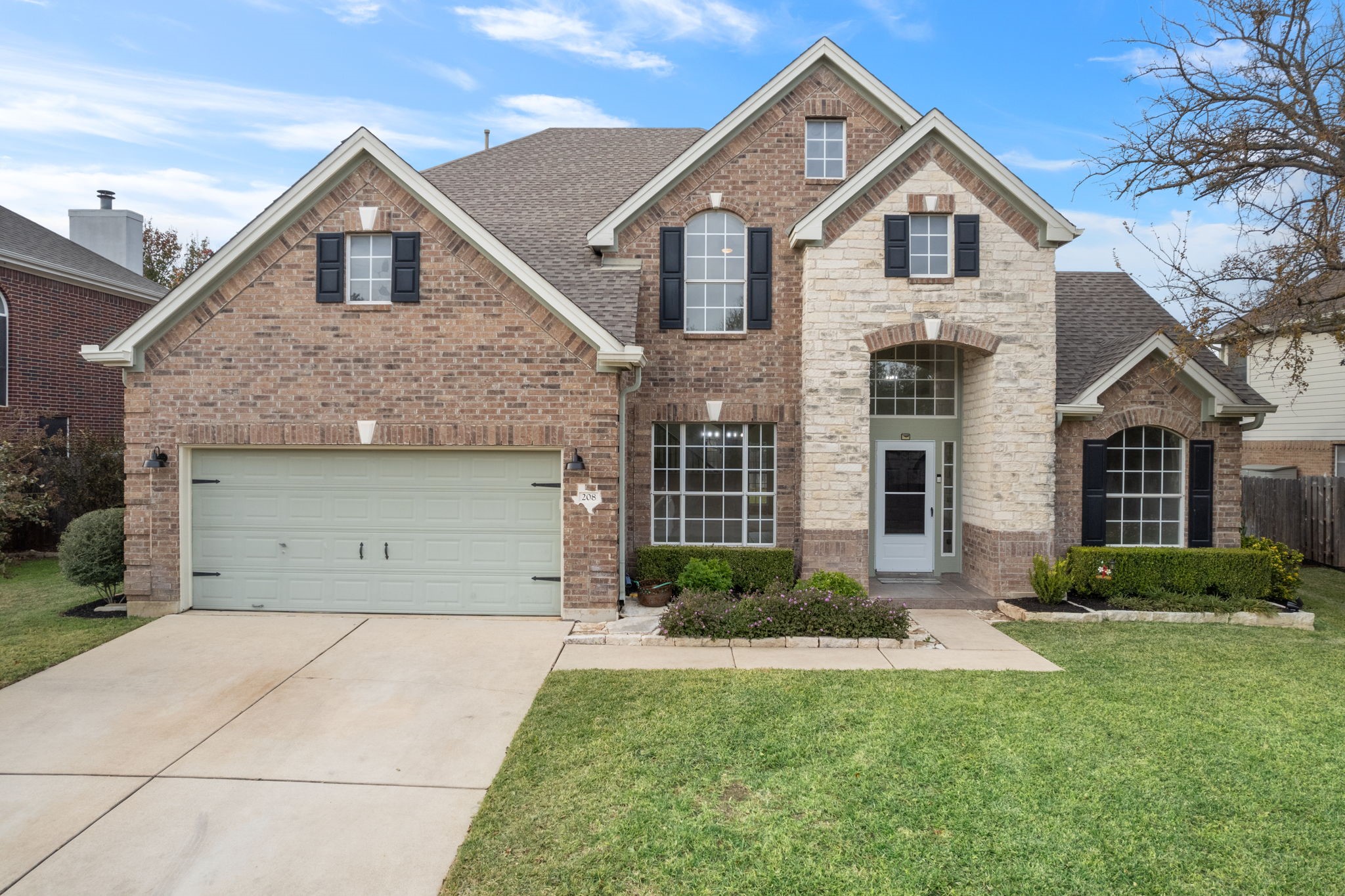 a front view of a house with a yard and garage