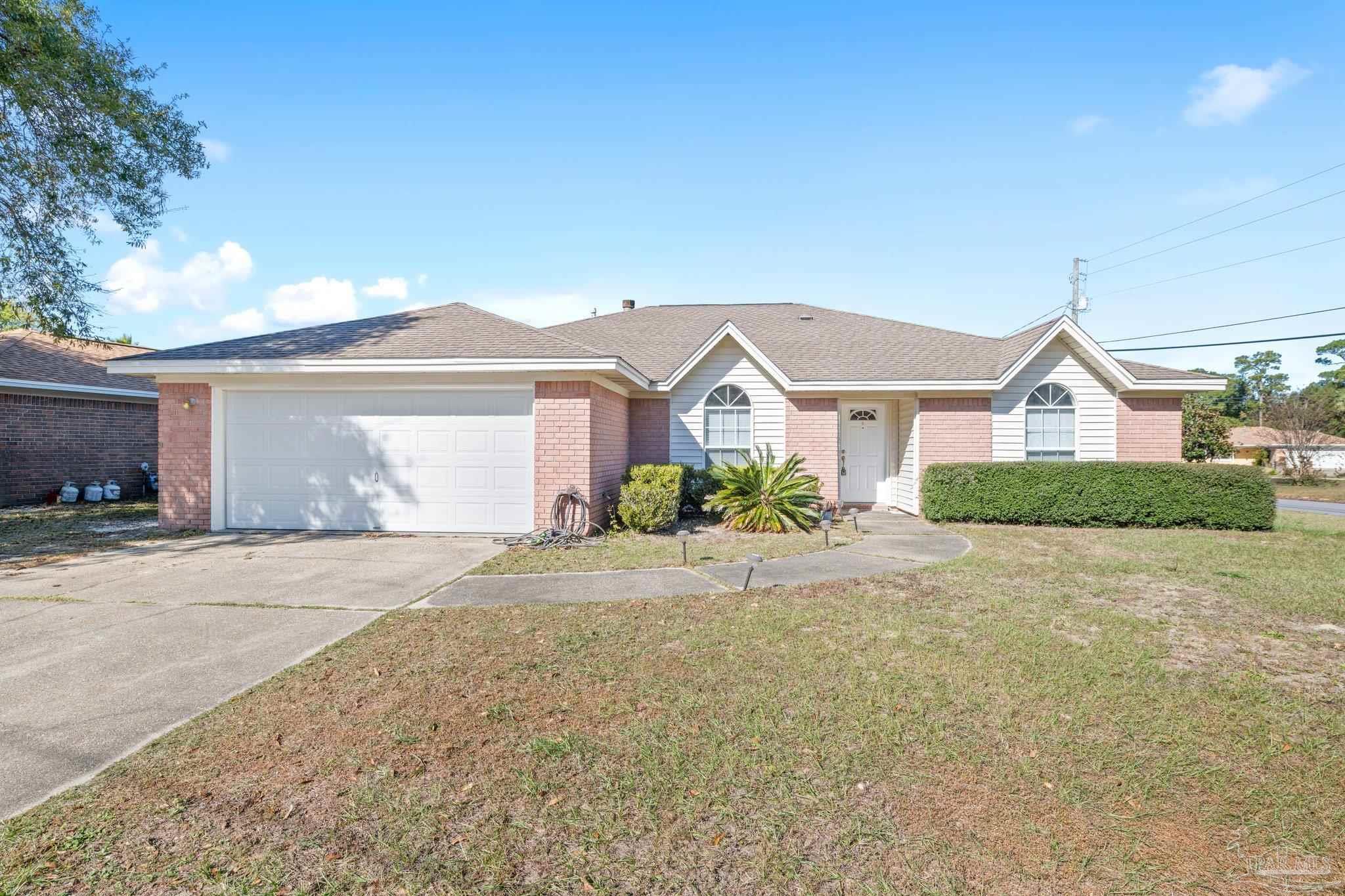 a front view of a house with a yard and a garage