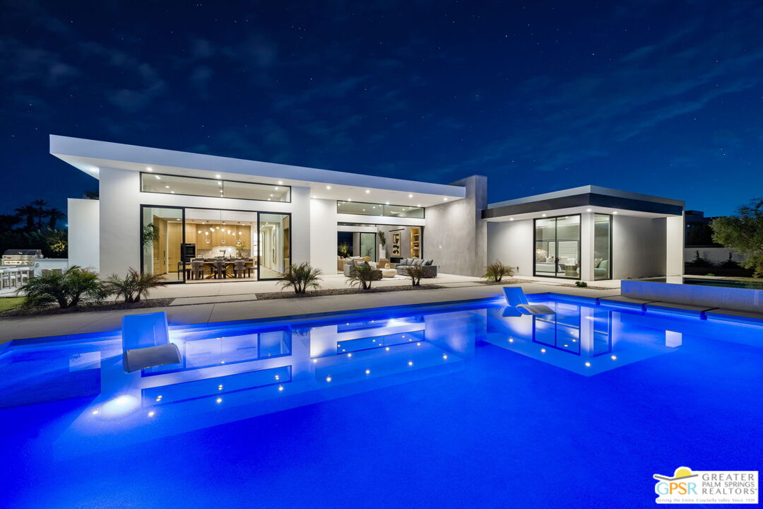 a living room with furniture a pool table and chairs with wooden floor