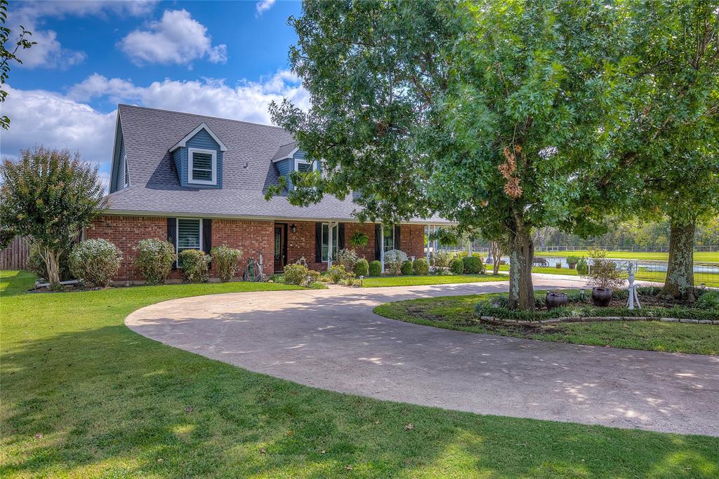 a front view of a house with yard and green space