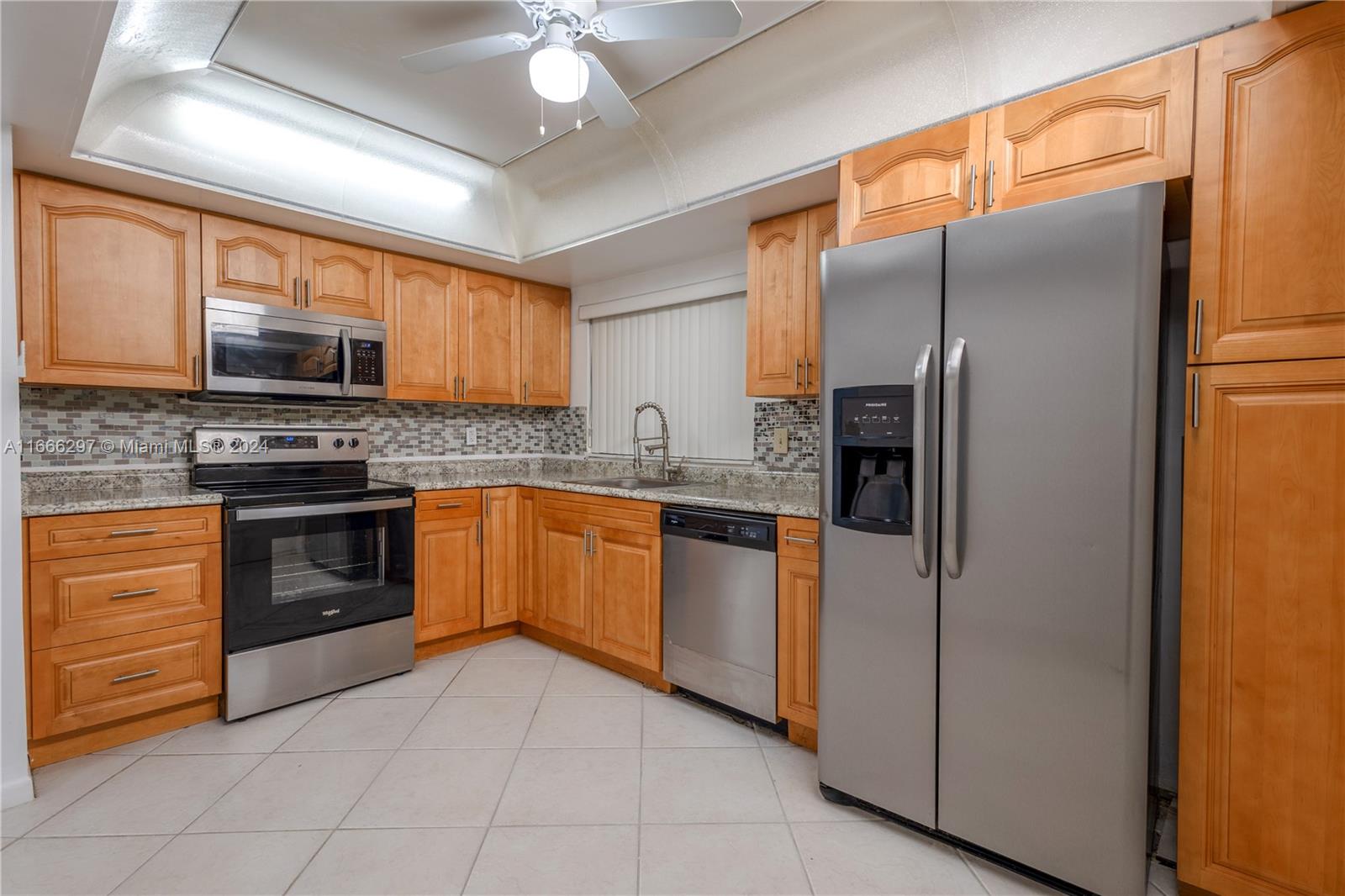 a kitchen with stainless steel appliances granite countertop a refrigerator a stove top oven a sink and dishwasher