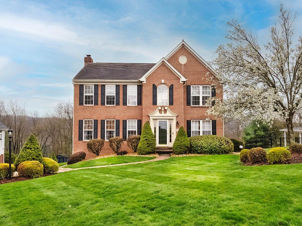 a front view of a house with a yard and green space