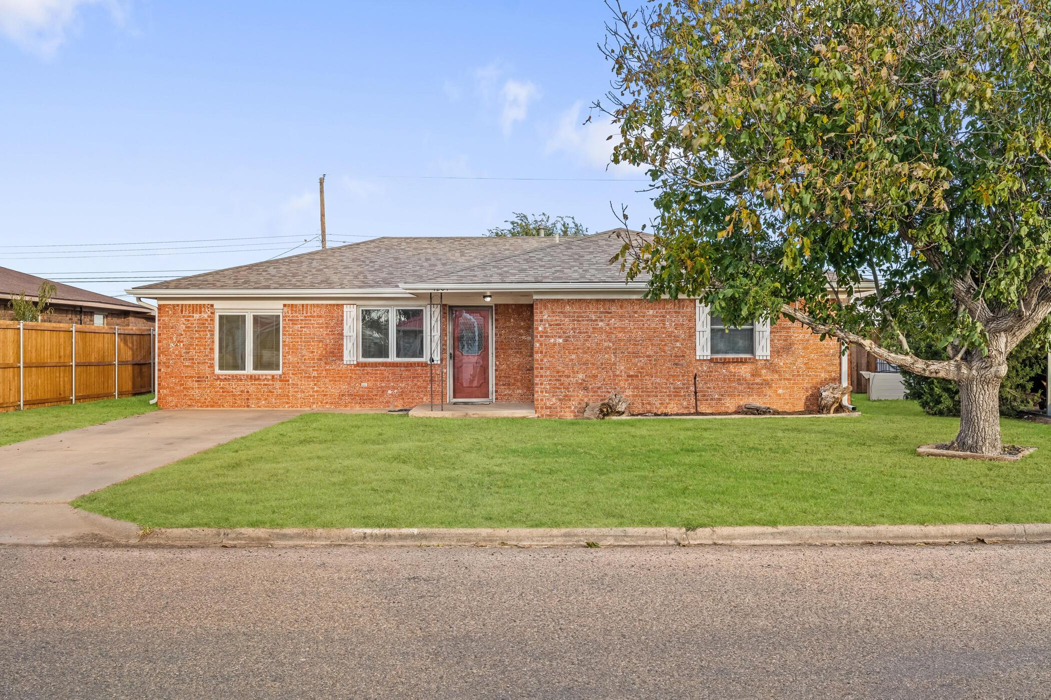 a front view of a house with a garden and trees