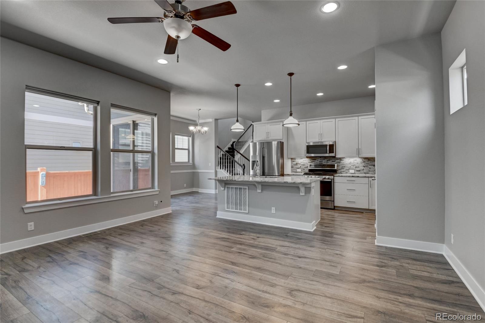 a kitchen with stainless steel appliances kitchen island wooden floors cabinets and a window