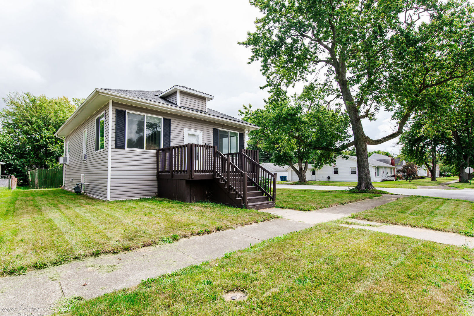 a front view of a house with yard and green space