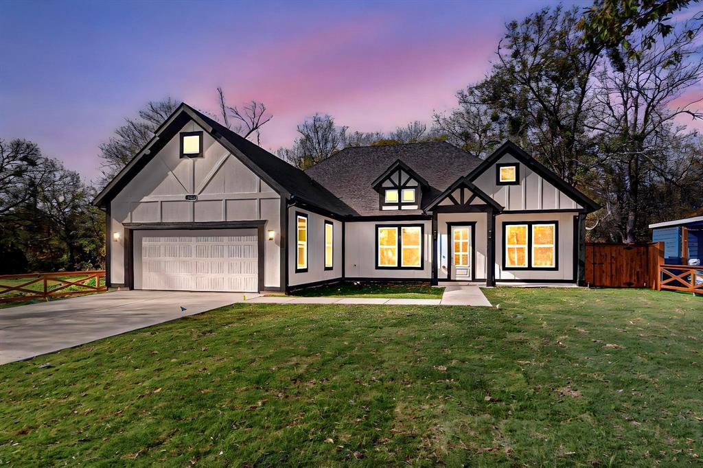 English style home with a lawn and a garage