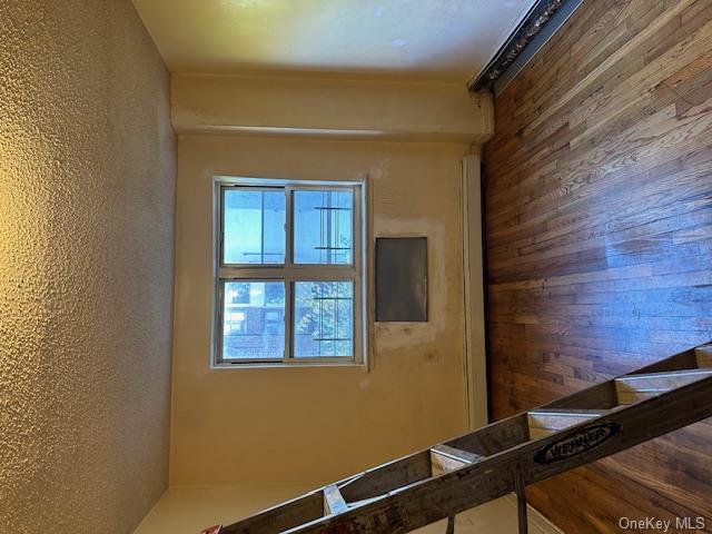 Unfurnished room with hardwood / wood-style flooring, a textured ceiling, and a baseboard radiator