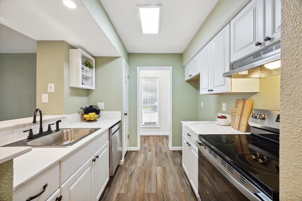 a kitchen with a sink a stove and cabinets