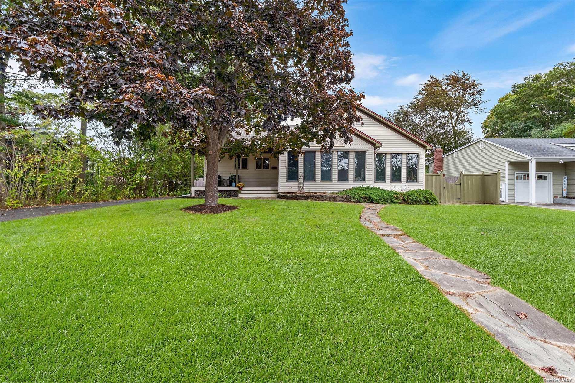 a view of house with a big yard and large trees