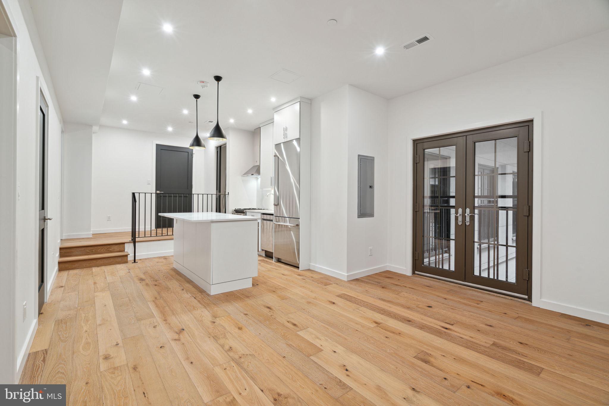 a view of a kitchen with refrigerator and wooden floor