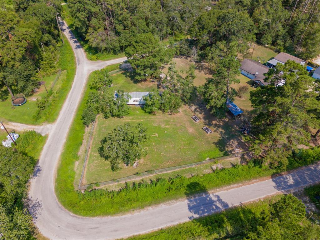 an aerial view of residential house with outdoor space and trees all around