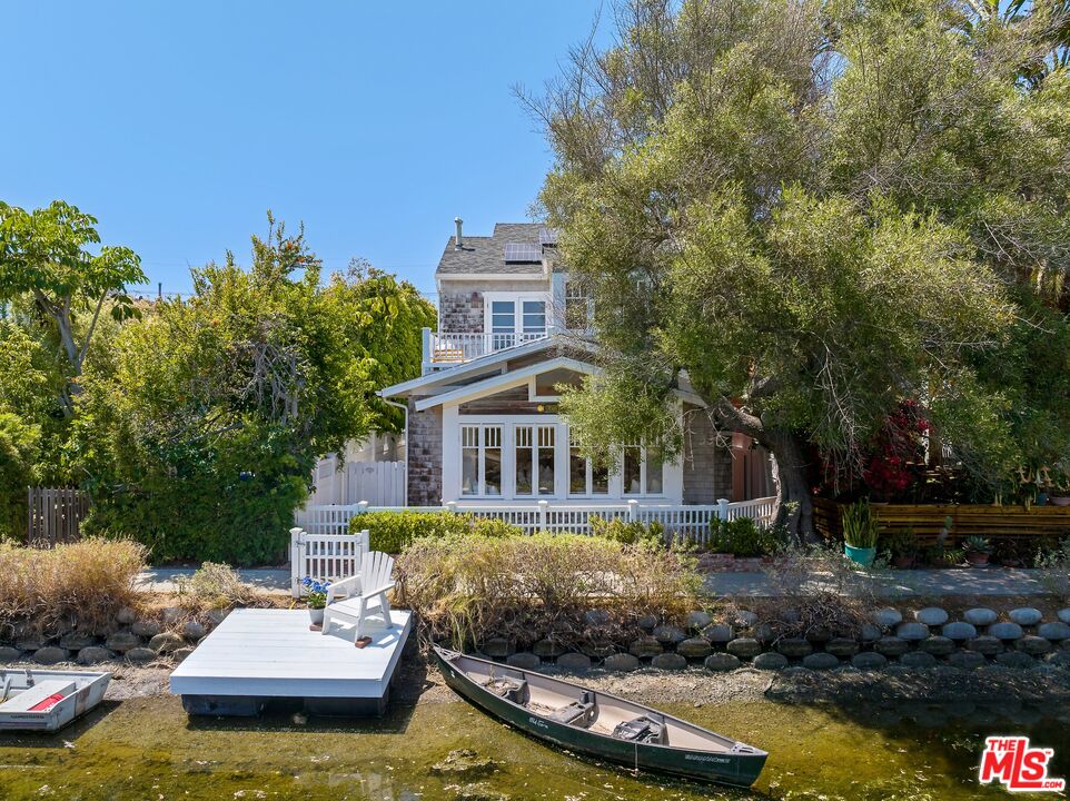 a front view of a house with a garden and swimming pool