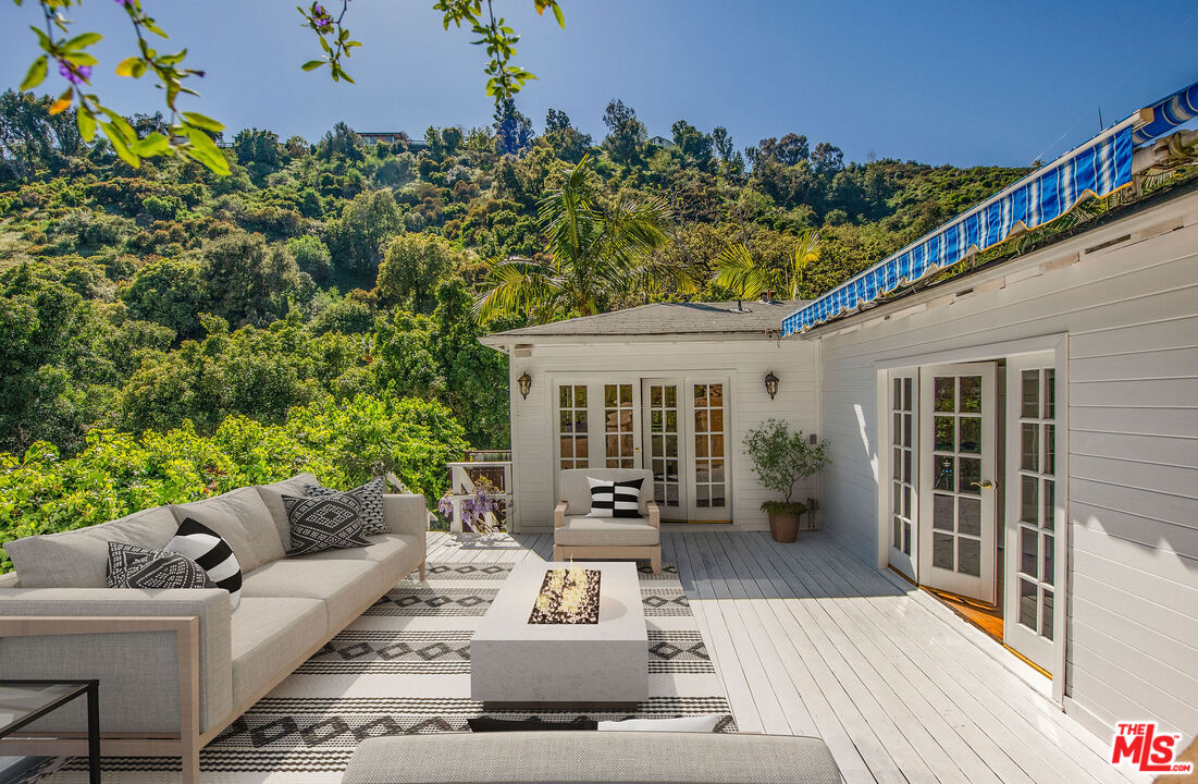 a view of a patio with couches plants and wooden floor