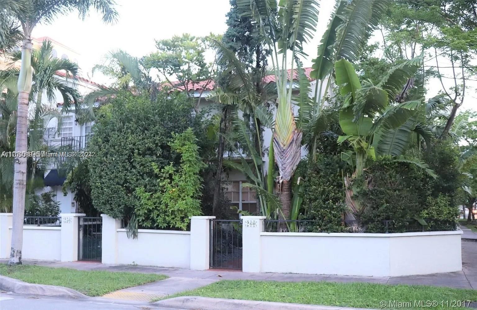 a view of a white house with a yard and large tree