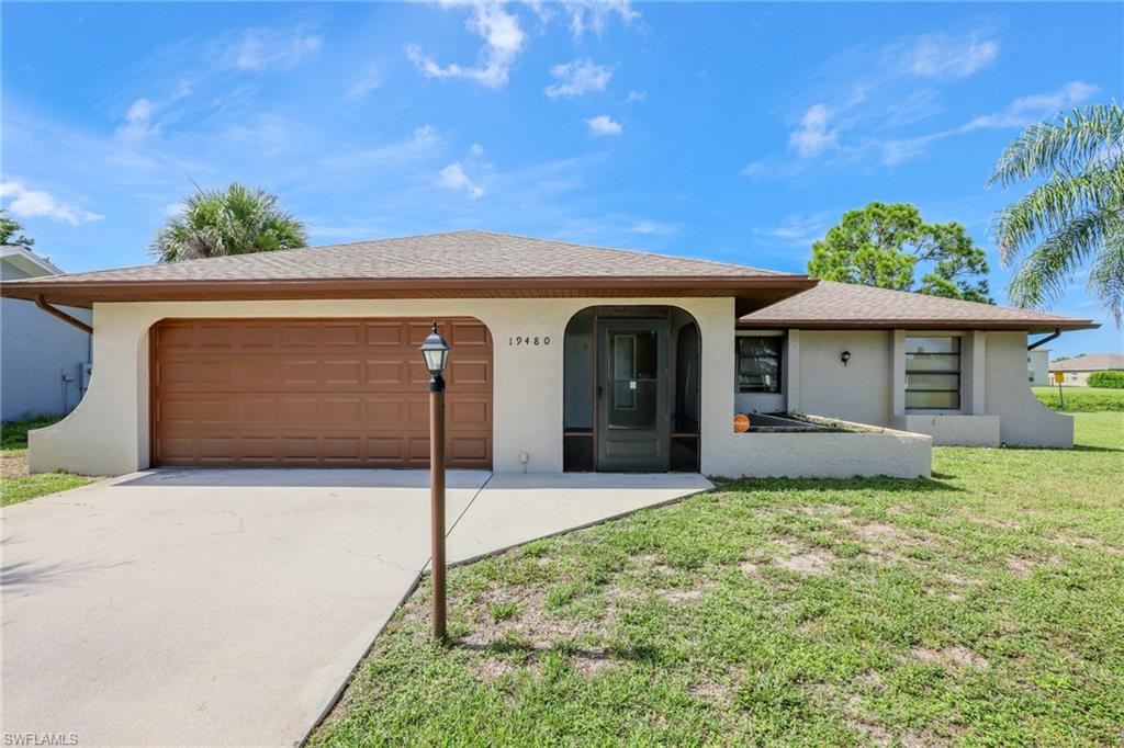 Single story home with a garage and a front yard