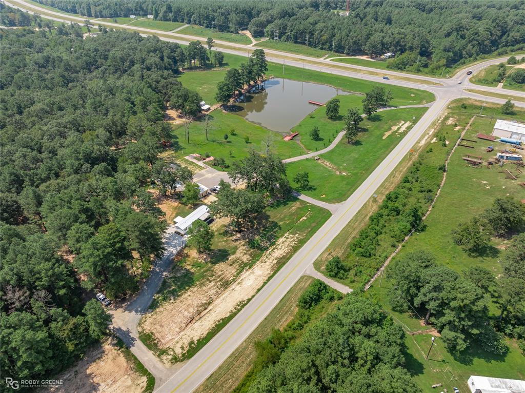 a view of a lake with a yard and large trees