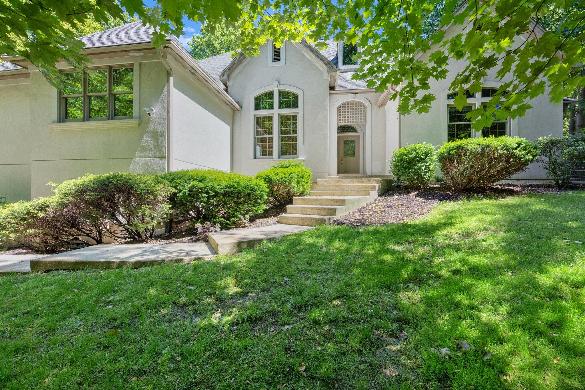 a front view of a house with a yard and potted plants