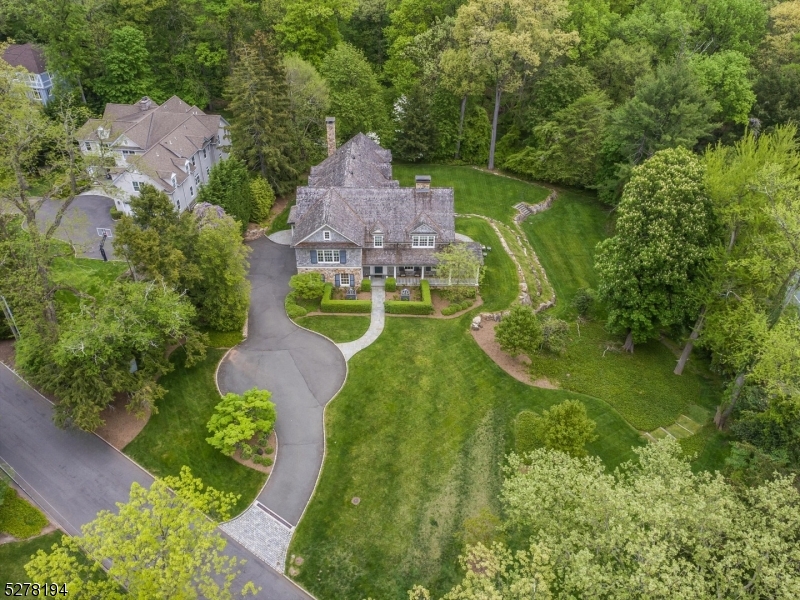 an aerial view of residential houses with outdoor space and trees