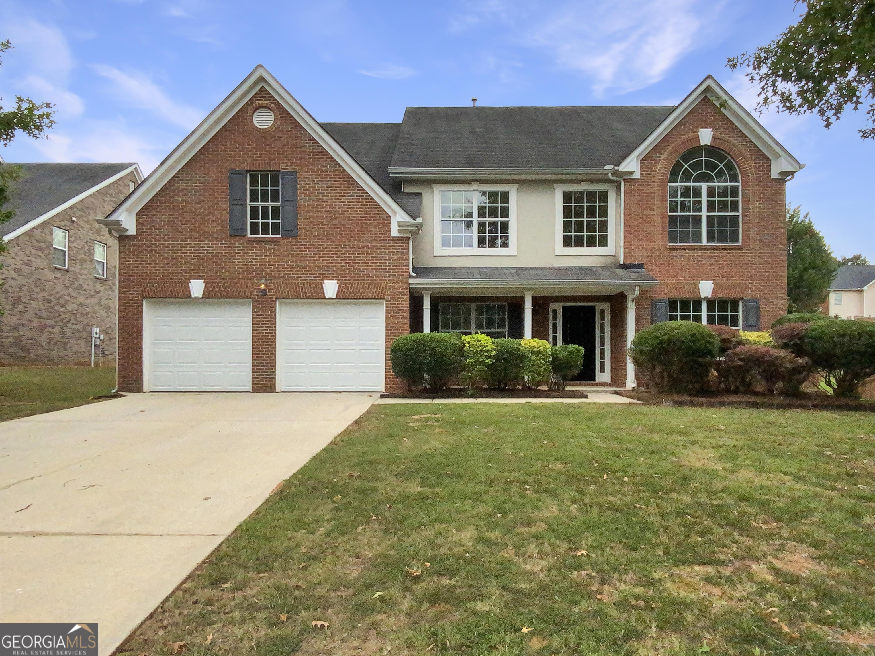 a front view of a house with a yard and garage