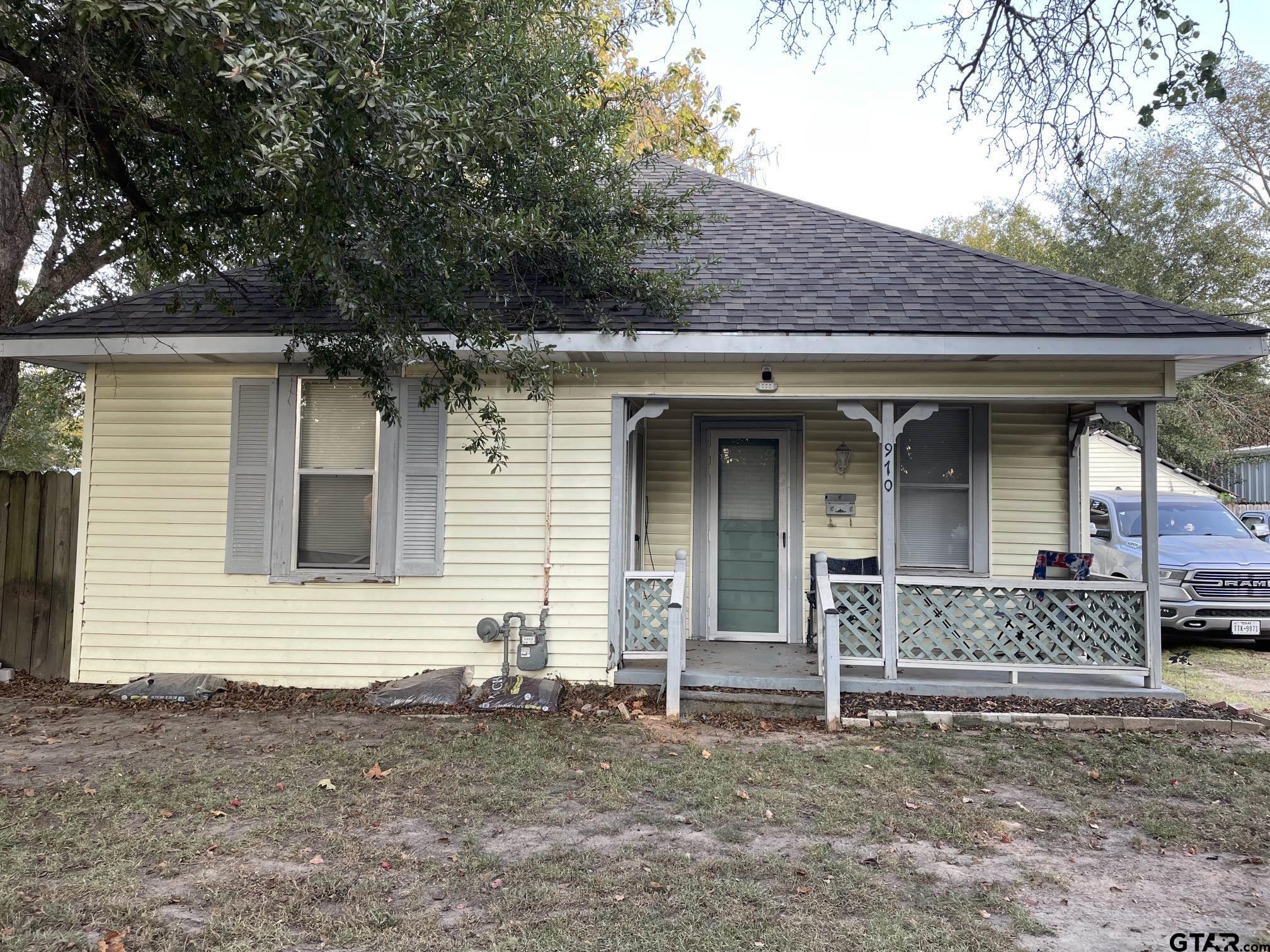 a front view of a house with a tree