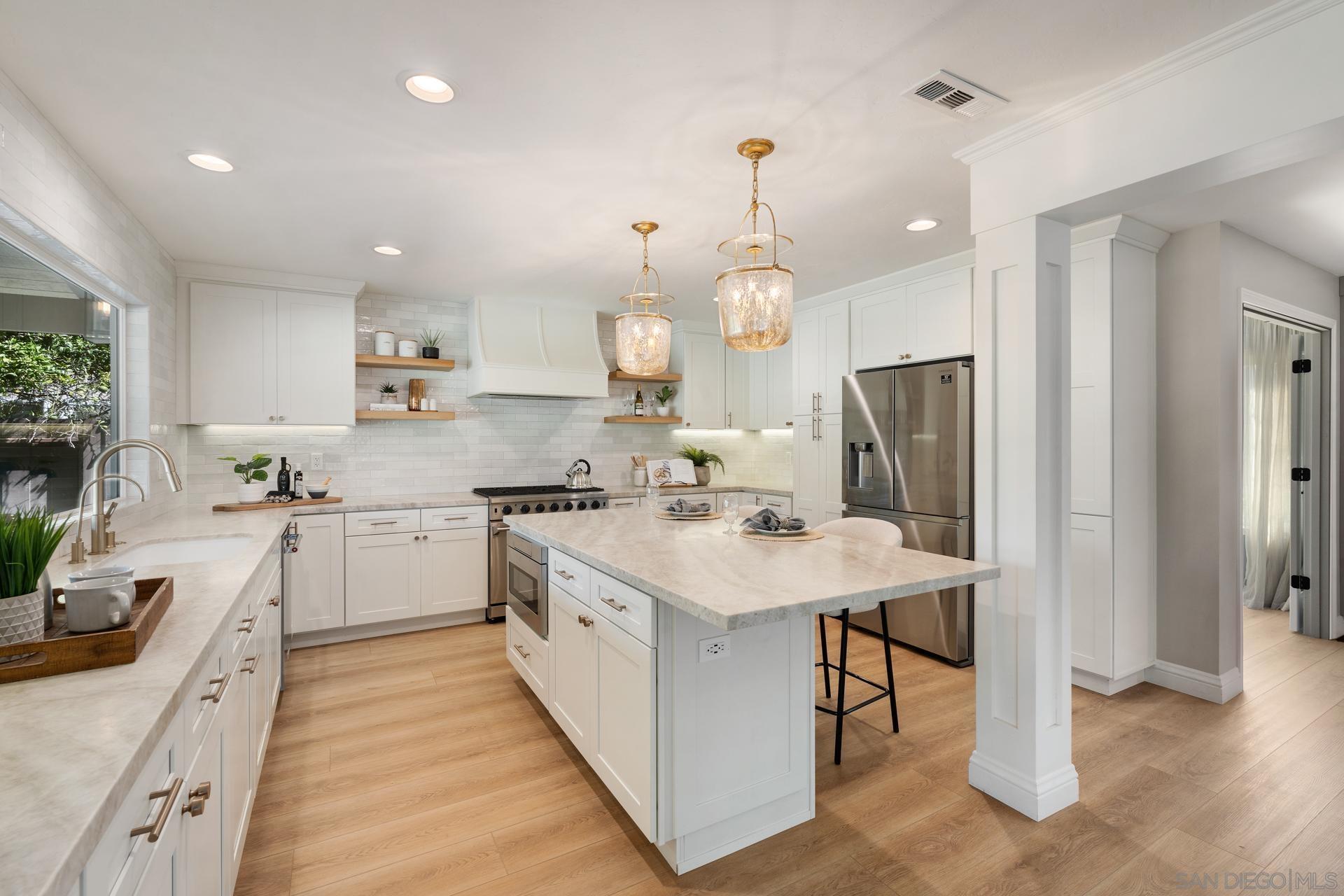 a kitchen with white cabinets and stainless steel appliances