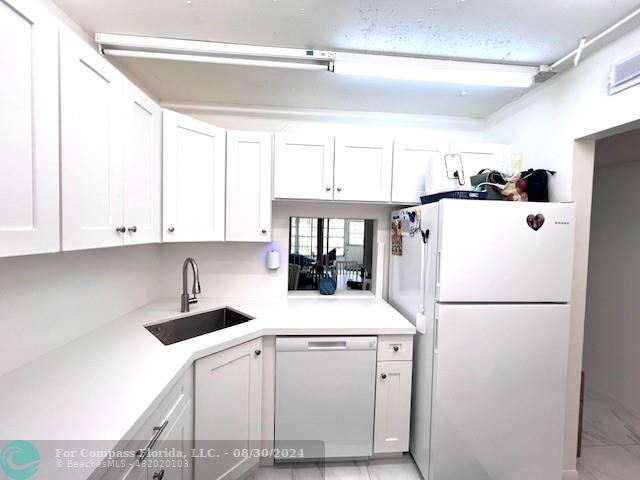 a kitchen with a refrigerator a sink and cabinets