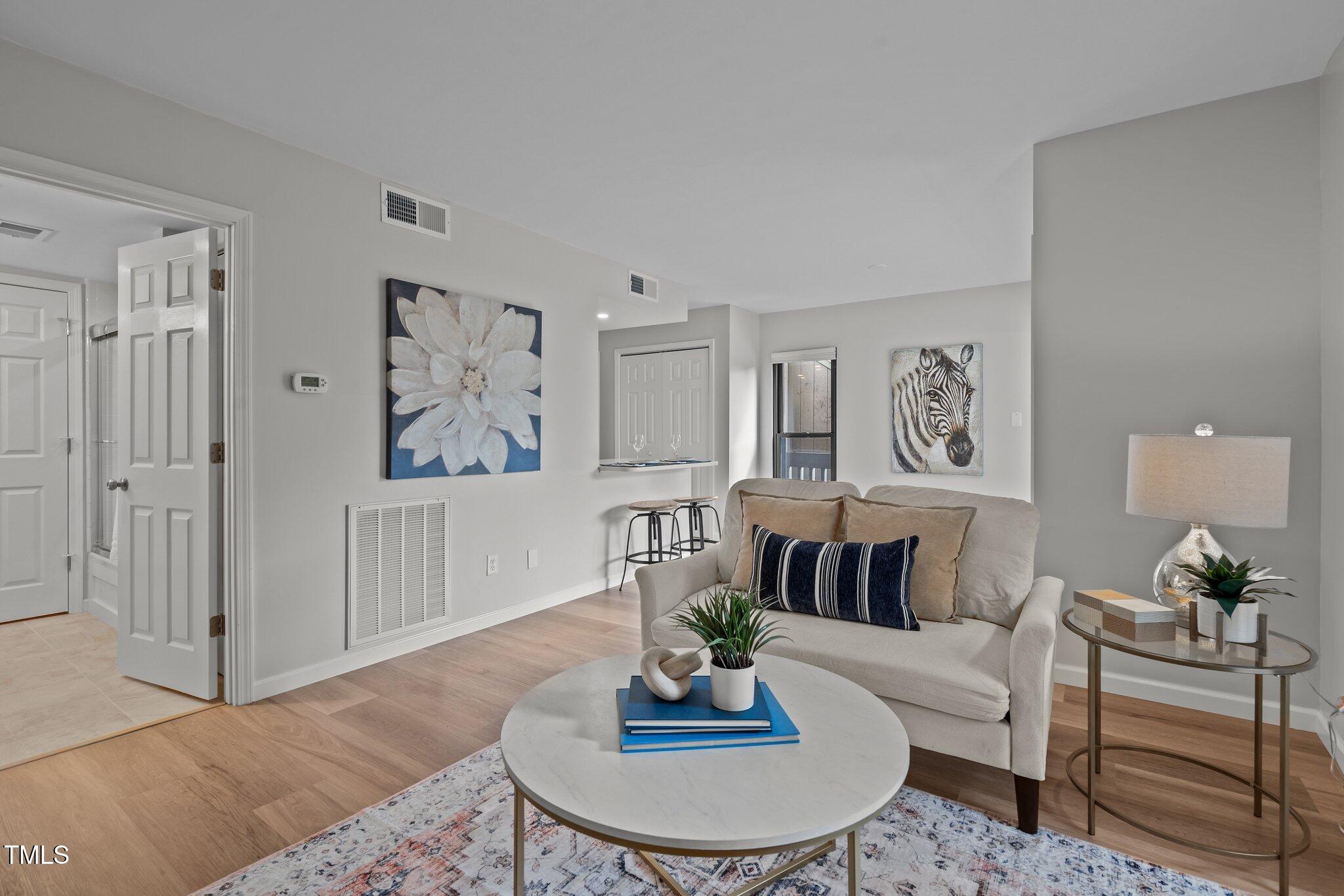 a living room with furniture and a wooden floor