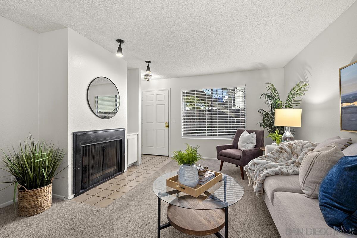 a living room with furniture a fireplace and a potted plant