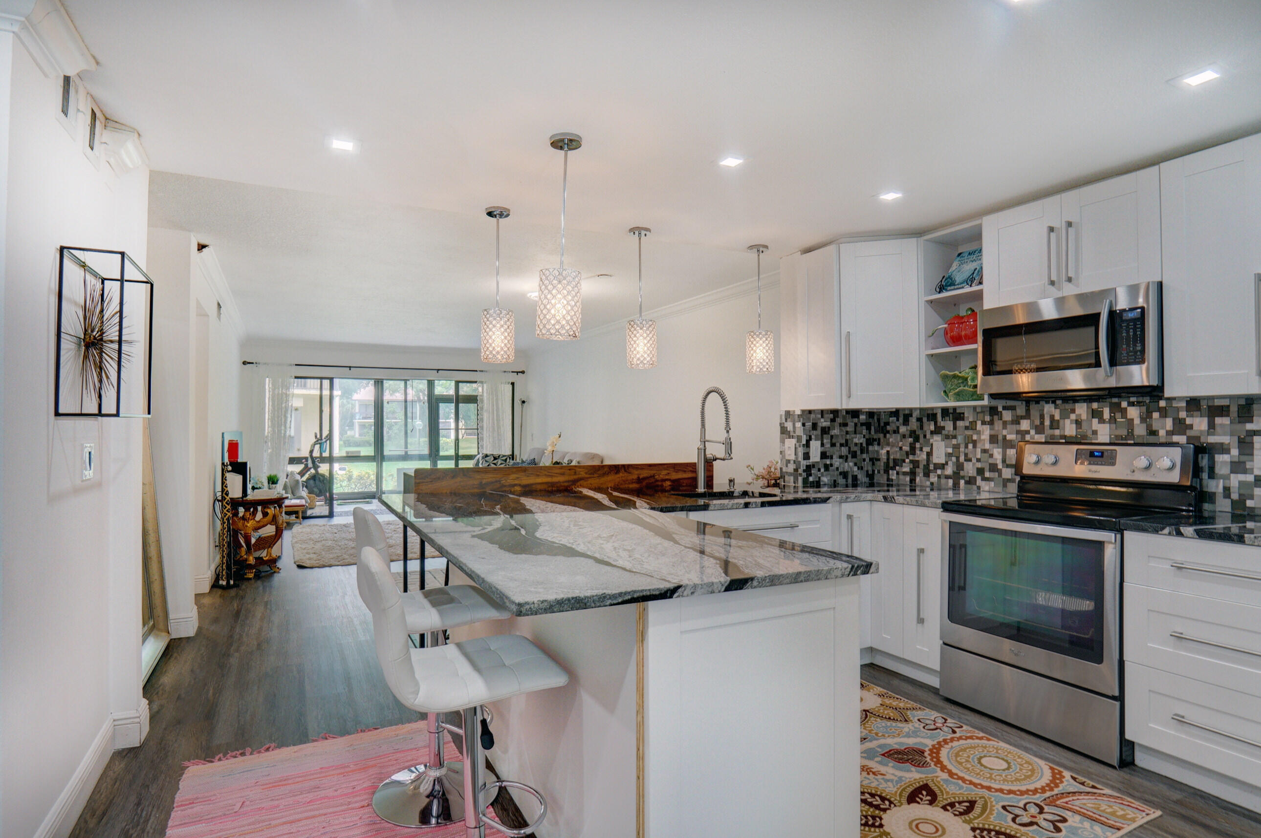 a kitchen with stainless steel appliances granite countertop a stove and a sink dishwasher with wooden floor