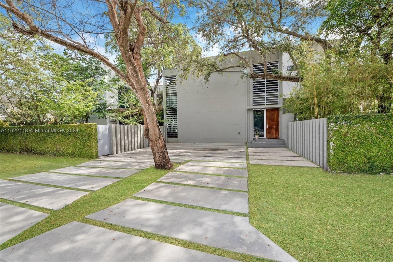 a front view of a house with a yard and tree s