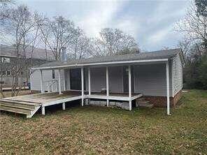 a wooden bench sitting in front of a house