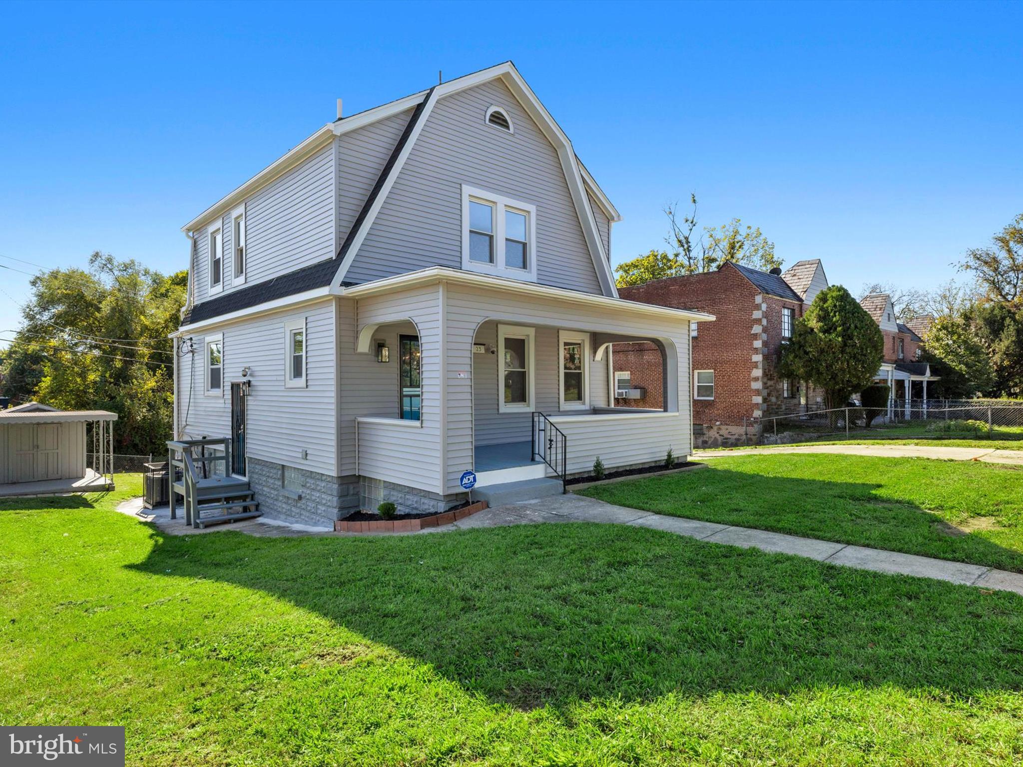 a front view of a house with a yard and trees