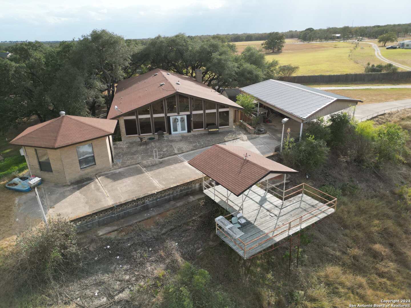 an aerial view of a house with pool and lake view