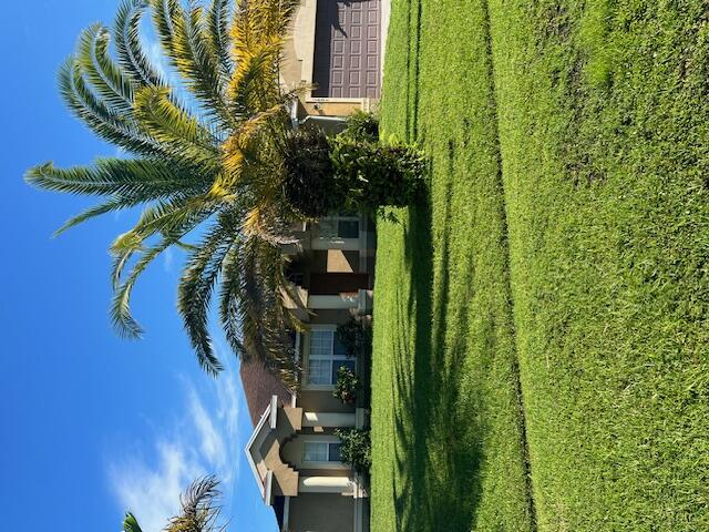 a view of a house with a big yard and potted plants