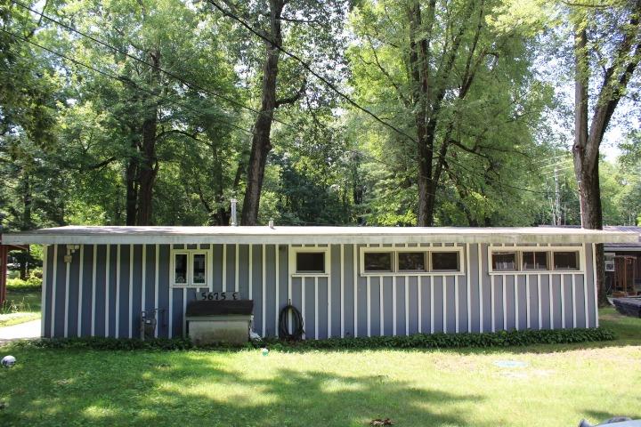 a view of a deck with a fence and large trees