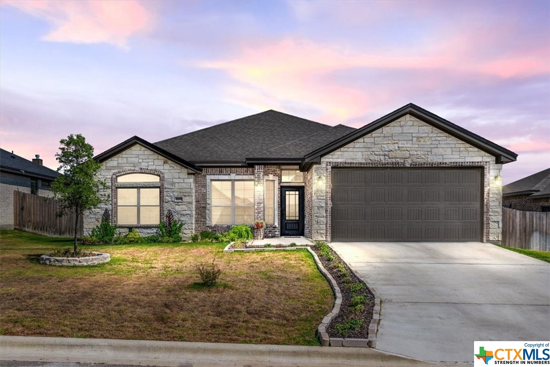 a front view of a house with yard and green space