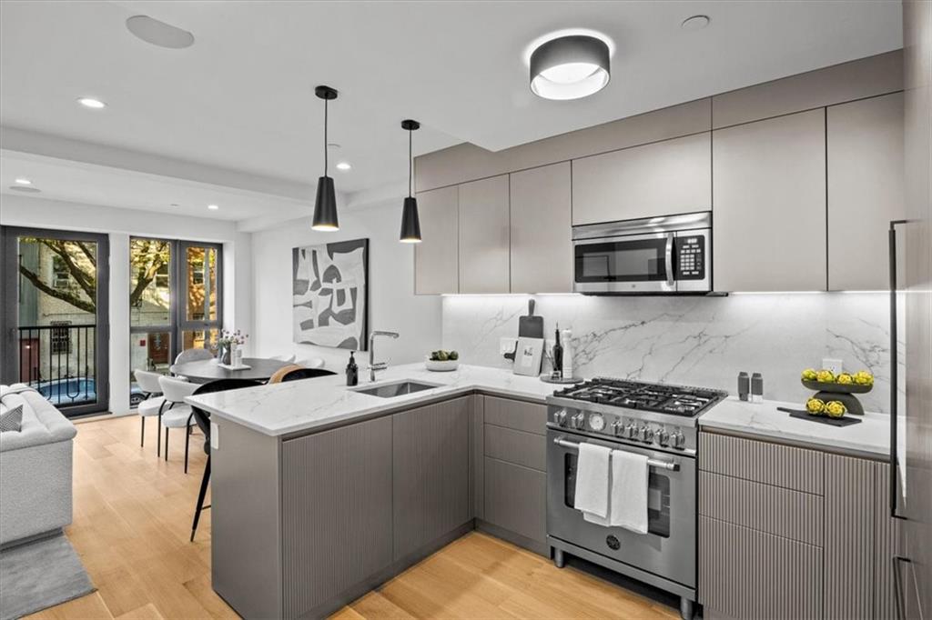 a kitchen with granite countertop a sink stainless steel appliances and cabinets