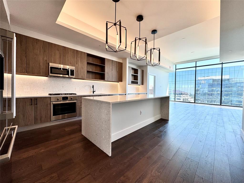 a kitchen with stainless steel appliances a stove top oven and a refrigerator