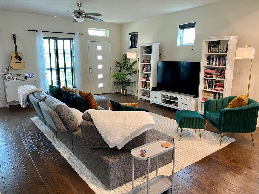 a living room with furniture a flat screen tv and a large window