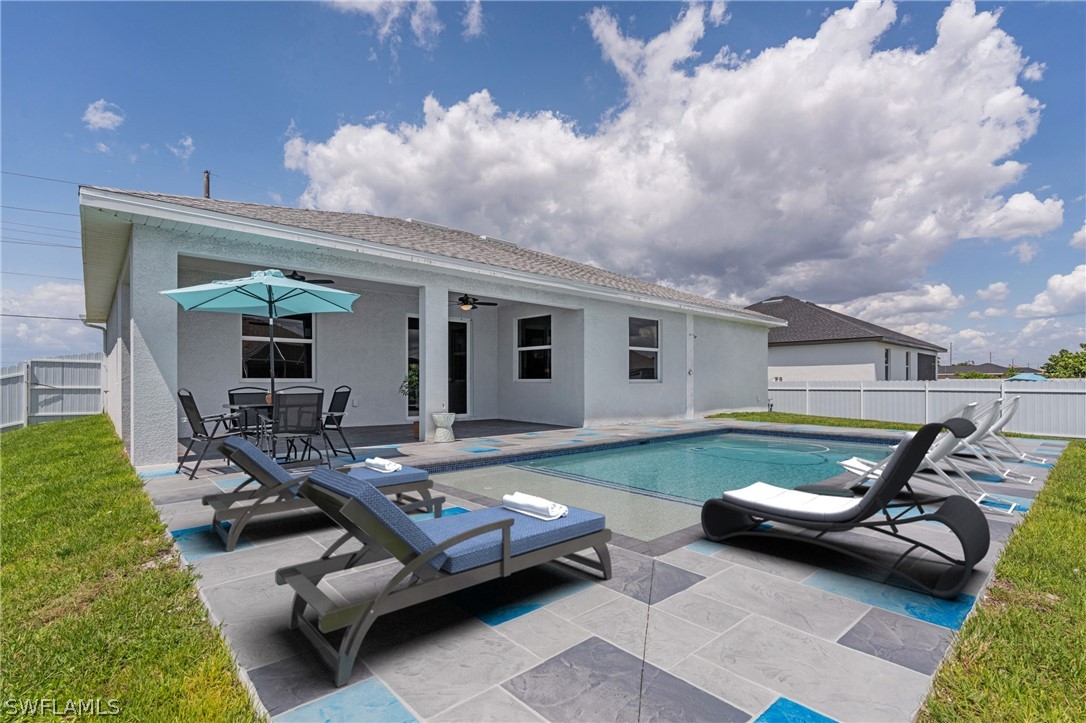 a backyard of a house with yard table and chairs