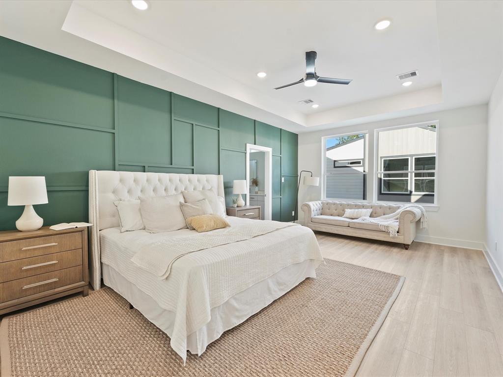 a spacious bedroom with a bed couch and window