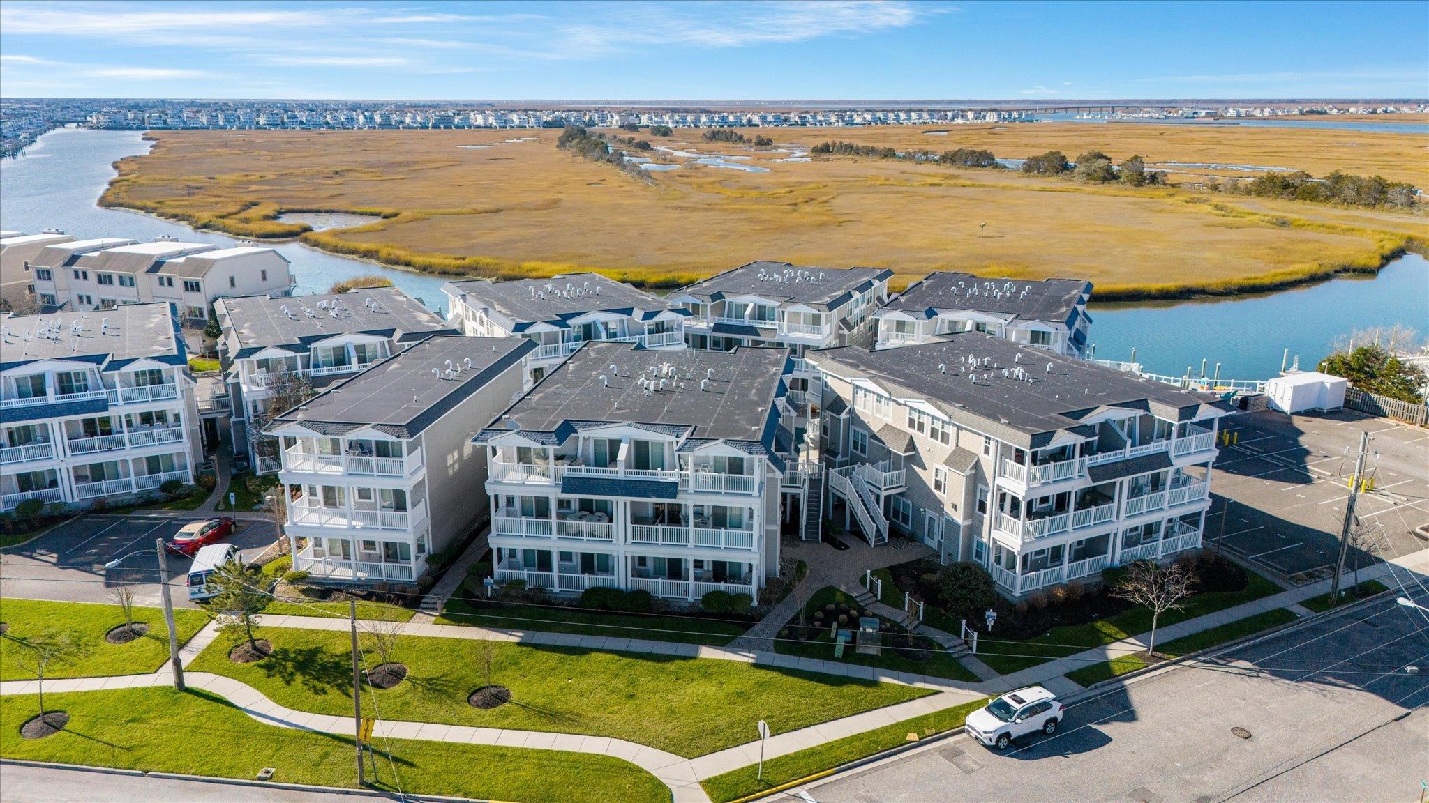 an aerial view of residential houses with outdoor space and ocean view