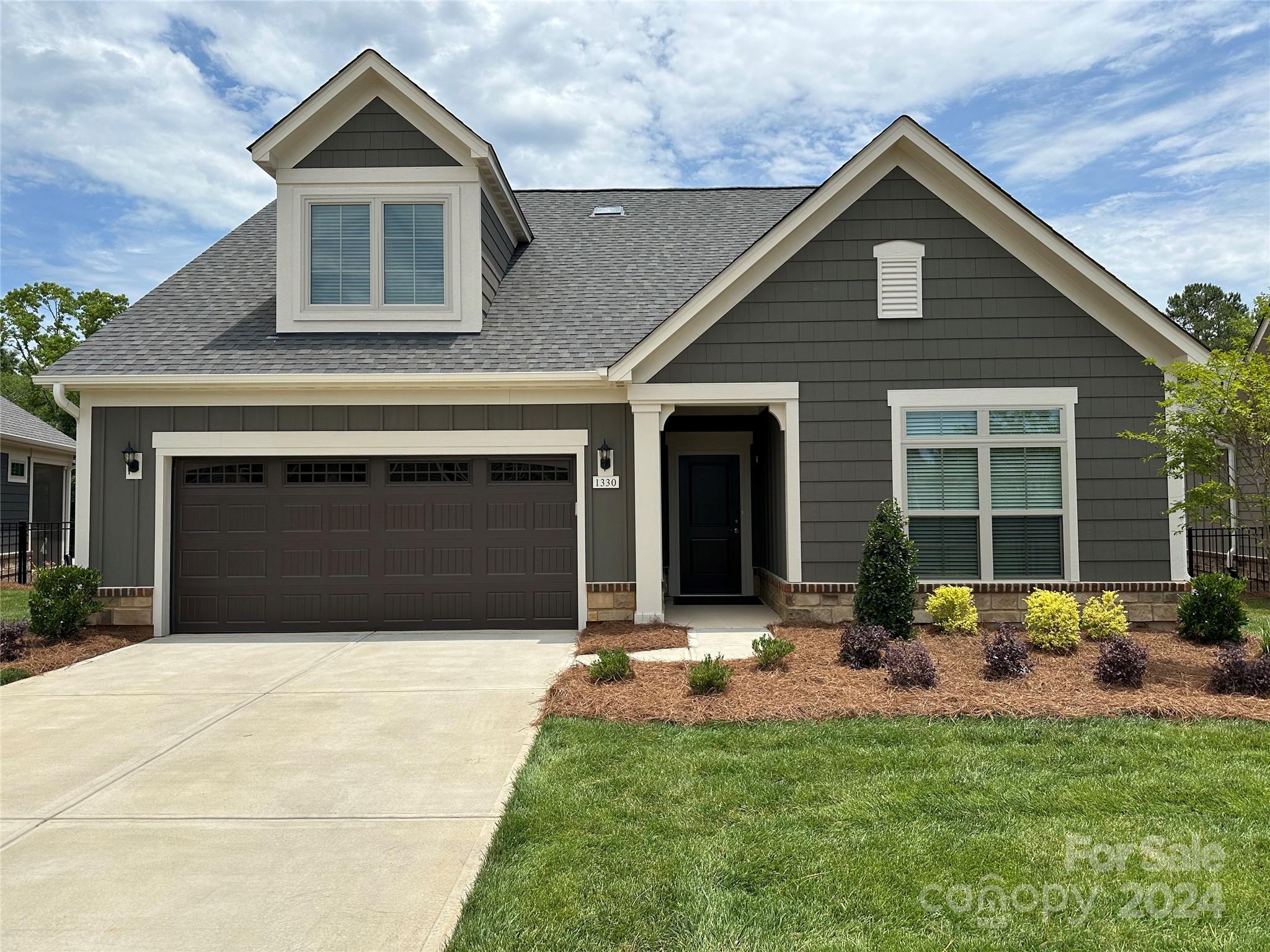 a front view of a house with a yard and outdoor seating